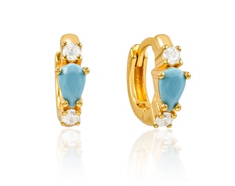 May include: Gold hoop earrings with a teardrop-shaped turquoise stone and clear cubic zirconia accents.
