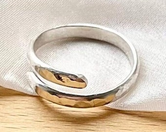May include: A silver hammered wrap ring with a textured finish.