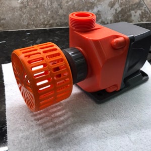 Puede incluir: Bomba de agua naranja y gris con una rejilla protectora naranja.