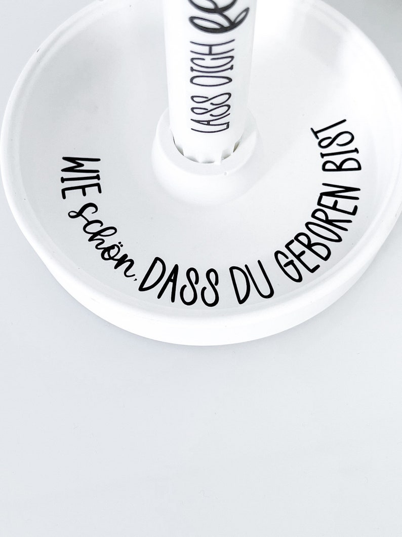 May include: White ceramic dish with black text that reads "Wie sch&ouml;n, dass du geboren bist".