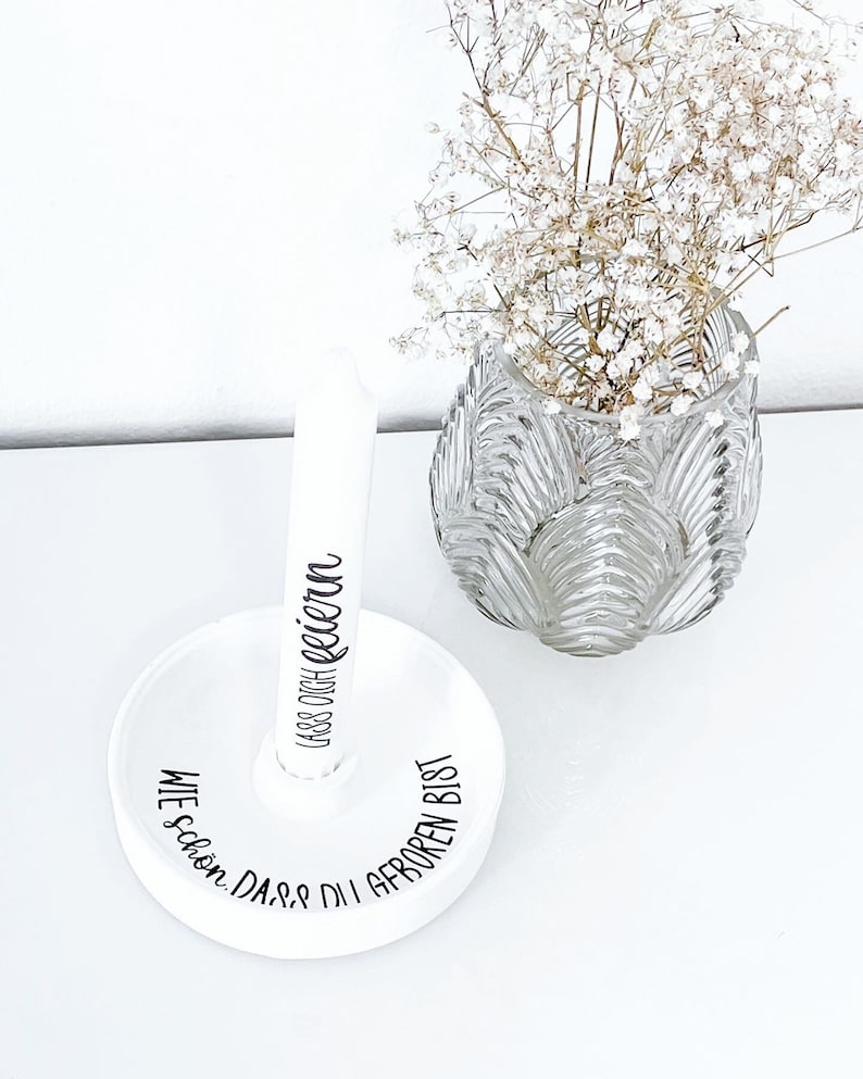 May include: White ceramic ring holder with the text "Wie sch&ouml;n, dass du geboren bist" and "Lass dich feiern" in black script.