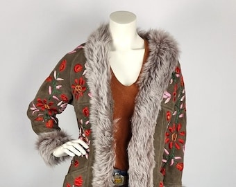 Könnte beinhalten: Eine grüne Wildlederjacke mit einem Kunstfellkragen und -futter. Die Jacke ist mit bunten Blumen bestickt.