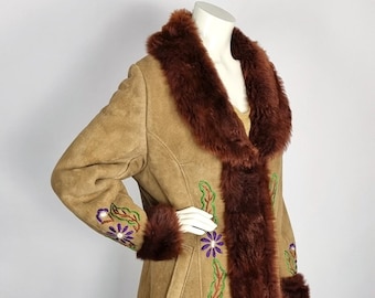 May include: A long brown suede coat with a brown faux fur collar and cuffs. The coat is embroidered with colorful flowers and leaves.