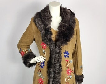May include: A long brown suede coat with a faux fur collar and cuffs. The coat is embroidered with colourful flowers.