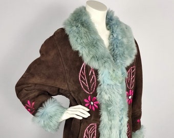 May include: A brown suede coat with a light blue faux fur collar and cuffs. The coat is embroidered with pink flowers and leaves.