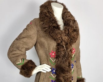 May include: A brown sheepskin coat with a fur collar and cuffs. The coat is embroidered with colourful flowers.