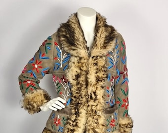 Könnte beinhalten: Eine braune Wildlederjacke mit einem Kunstfellkragen und -ärmelaufschlägen. Die Jacke ist mit bunten Blumen und Blättern bestickt.