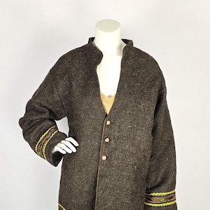 May include: A dark brown wool coat with a mandarin collar and three wooden buttons. The sleeves have decorative trim in yellow, brown, and green. The coat is displayed on a mannequin.