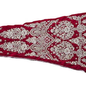 Può includere: Un lungo tessuto di velluto bordeaux con ricami argentati intricati. Il tessuto presenta un motivo floreale con un motivo ripetitivo.