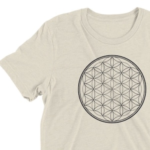 May include: A beige t-shirt with a black outline of the Flower of Life geometric pattern.
