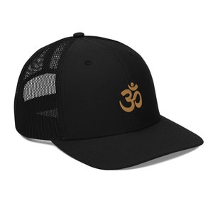 May include: A black trucker hat with a brown embroidered Om symbol.