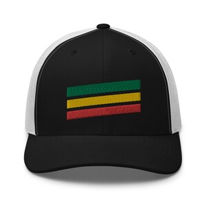 Puede incluir: Gorra de camionero negra y blanca con un dise&ntilde;o de bandera a rayas verdes, amarillas y rojas en la parte delantera.