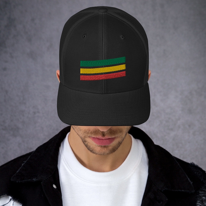 Puede incluir: Una gorra de camionero de malla negra con un dise&ntilde;o de rayas horizontales verde, amarillo y rojo en la parte delantera.