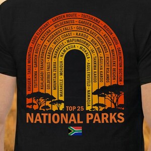 Peut inclure: T-shirt noir avec un graphisme coloré des parcs nationaux sud-africains. Le motif comprend une arche avec les noms des parcs et le texte "TOP 25 NATIONAL PARKS". Le drapeau sud-africain est en bas.