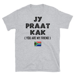 May include: Gray t-shirt with black text that reads "Jy Praat Kak (You Are My Friend)" and a South African flag.