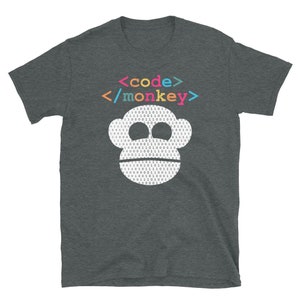 Może przedstawiać: Szary t-shirt z nadrukiem białej twarzy małpy. Twarz małpy składa się z kodu binarnego, a tekst "<code/>/monkey>" jest nadrukowany nad twarzą małpy w kolorach tęczy.