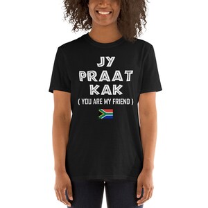 May include: Black t-shirt with white text that reads "Jy Praat Kak (You Are My Friend)" and a South African flag.