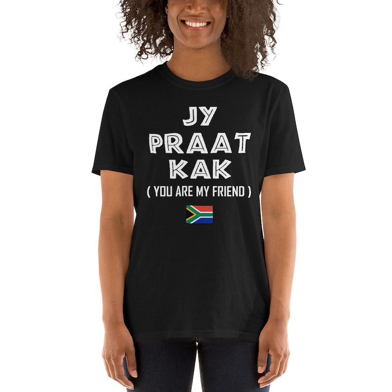 May include: Black t-shirt with white text that reads "Jy Praat Kak (You Are My Friend)" and a South African flag.