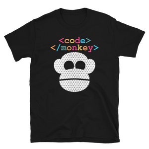 Może przedstawiać: Czarny T-shirt z białą twarzą małpy wykonaną z kodu binarnego. Tekst "<code>/monkey>" jest nadrukowany w kolorach tęczy nad małpą.