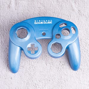 May include: A white ceramic mug with a black handle and the text "But First, Coffee" in a handwritten style. The mug is on a white surface. The mug is approximately 4 inches tall.