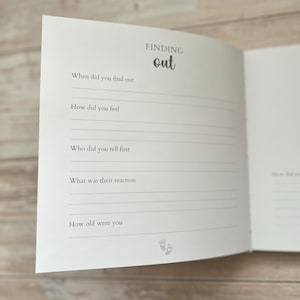 May include: Open journal page with the heading "FINDING out" in a handwritten font. The page includes prompts such as "When did you find out" and "How did you feel?" with lines for writing. Small baby feet icons are at the bottom.