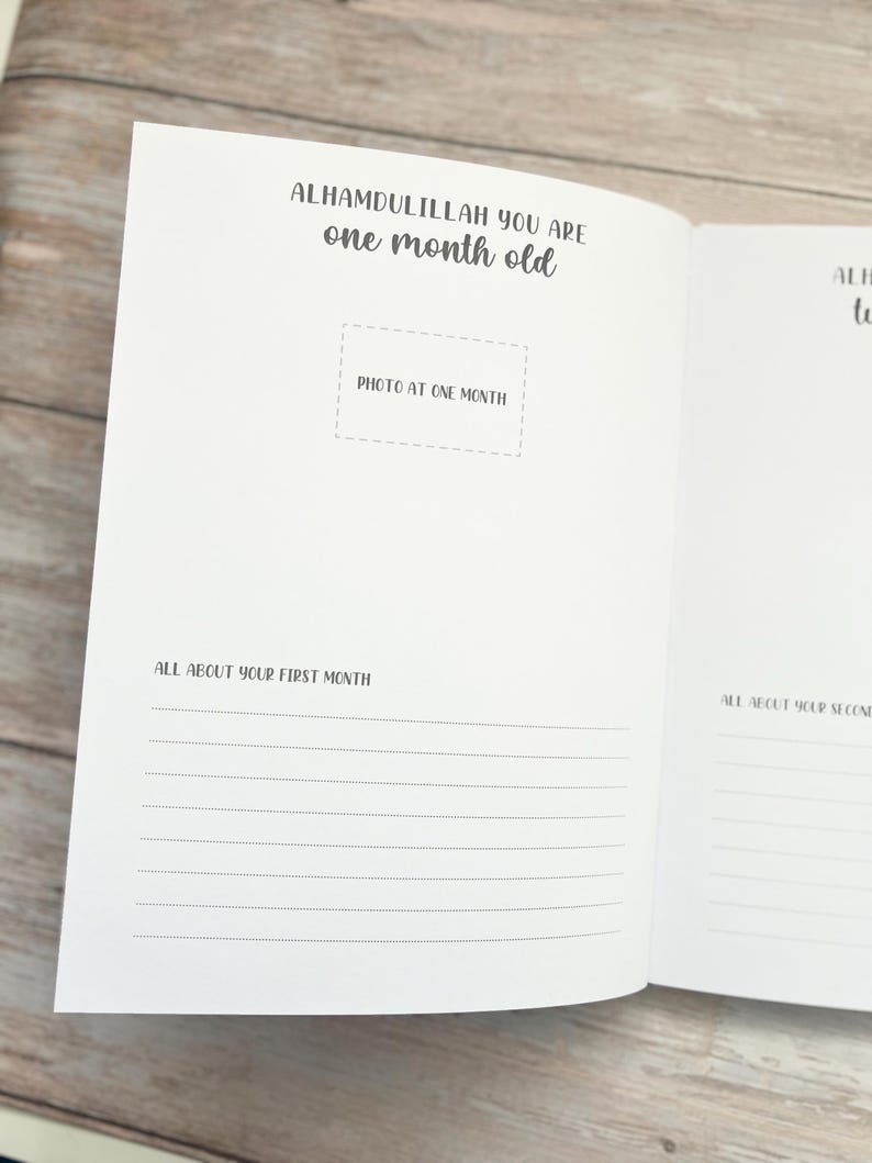 Pode incluir: Um di&aacute;rio de beb&ecirc; branco com o texto "Alhamdulillah you are one month old" e um espa&ccedil;o para uma foto. O di&aacute;rio tem linhas para escrever sobre o primeiro m&ecirc;s do beb&ecirc;.