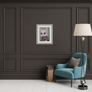 May include: A framed painting of a white cat wearing round sunglasses and a striped sweater. The cat is looking directly at the viewer. The painting is set against a green background.
