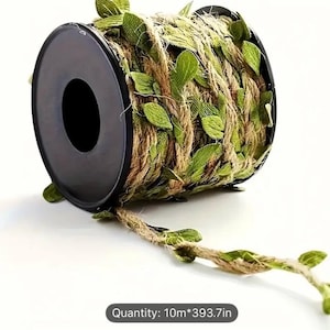 May include: A spool of decorative jute rope with green leaves. The rope is wrapped around a black spool, with some rope extending out. The text "Quantity: 10m*393.7in" is visible.
