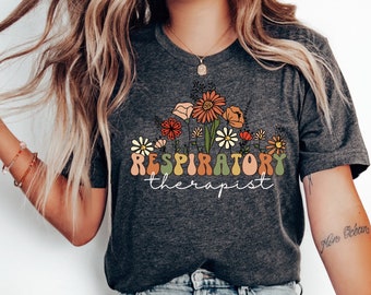 May include: A dark grey heather t-shirt with a floral design and the text "RESPIRATORY therapist".