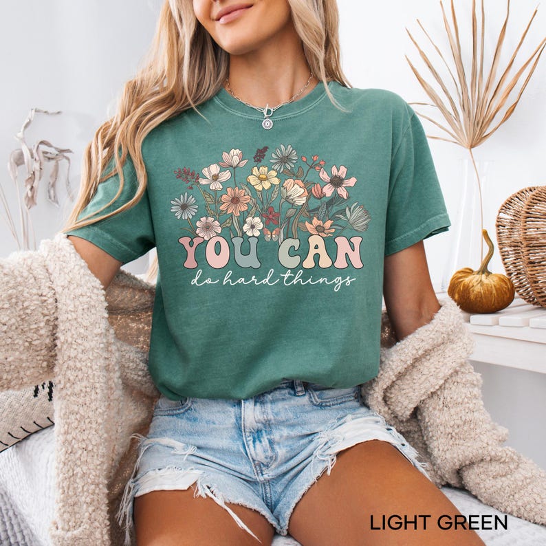 May include: A light green t-shirt with a floral design and the text "YOU CAN do hard things".