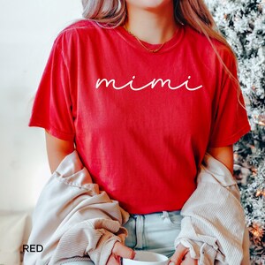 May include: A red t-shirt with the word "mimi" written in white cursive lettering.