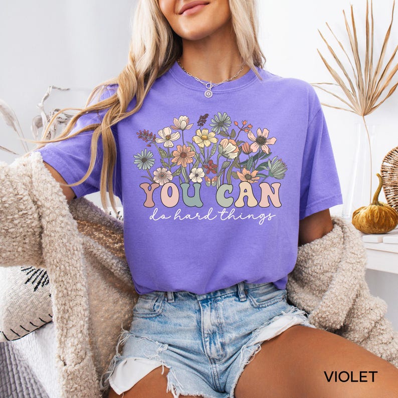 May include: A purple t-shirt with a floral design and the text "YOU CAN do hard things".