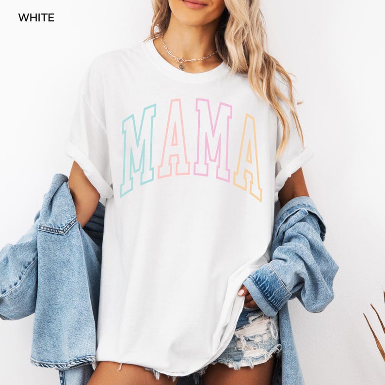 May include: White t-shirt with a rainbow colored "MAMA" graphic.
