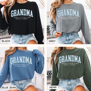 May include: A long-sleeved sweatshirt with the word "GRANDMA" in a textured font. Below the word are the names "EMMA TYLER AVA HENRY JAMES". The sweatshirt is available in black, grey, blue jean, and hemp colors.