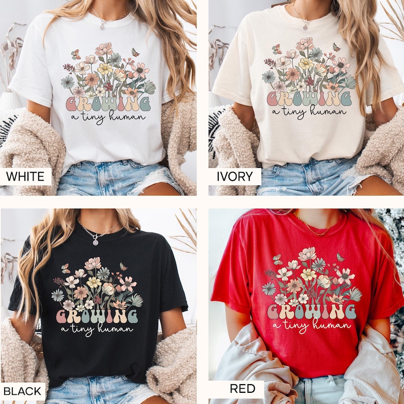 May include: Four t-shirts in white, ivory, black, and red. Each shirt features a floral design with the text "GROWING a tiny human" in a pastel color palette. The shirts are short-sleeved.