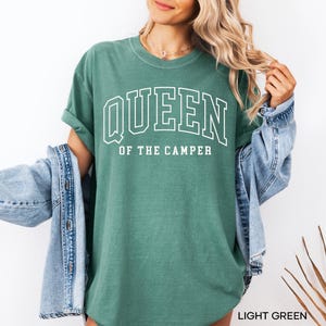 May include: A light green t-shirt with the text "QUEEN OF THE CAMPER" in white.