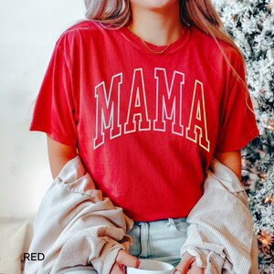 May include: Red t-shirt with the word "MAMA" in a rainbow gradient font.