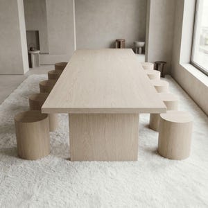 modern oak dining table with cylindrical stools around table in spacious contemporary interior