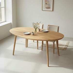 May include: An oval wooden dining table with four tapered legs. Two chairs with beige upholstered seats are positioned behind the table. The table is set with plates, mugs, and a vase of flowers. The table is approximately 72 inches long.