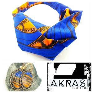 May include: A blue and orange patterned headband with a knot in the centre. The headband is made of fabric and is designed to be worn around the head. The headband is shown on a white background. The image also shows a pair of earrings with a blue and orange patterned design. The earrings are made of metal and have a hook fastening. The earrings are shown on a brown background. The image also includes the text "AKRAS" and "BOUTIQUE".