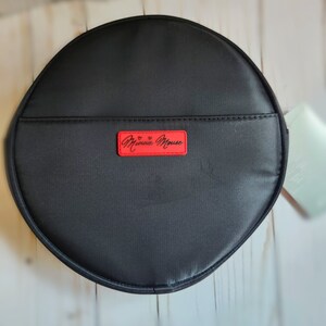 May include: A black round zippered pouch with a red label that says "Minnie Mouse" in white lettering.