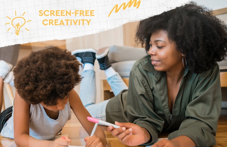 May include: An image shows two people lying on a wooden floor, drawing with markers. The text "SCREEN-FREE CREATIVITY" is visible. One person is wearing a green shirt, and the other is wearing a gray shirt. The image has a warm, inviting feel.