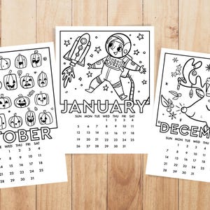 May include: Three black and white printable calendar pages featuring illustrations of a pumpkin, an astronaut, and a reindeer. The calendar pages are for October, January, and December.