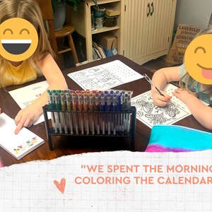 May include: Two children are coloring at a table, with a variety of gel pens in a black stand. They are using coloring pages and notepads. The text in the image says, "WE SPENT THE MORNING COLORING THE CALENDAR!"