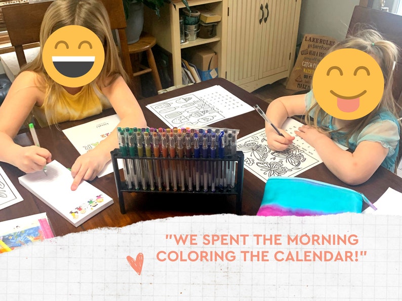 May include: Two children are coloring at a table, with a variety of gel pens in a black stand. They are using coloring pages and notepads. The text in the image says, "WE SPENT THE MORNING COLORING THE CALENDAR!"