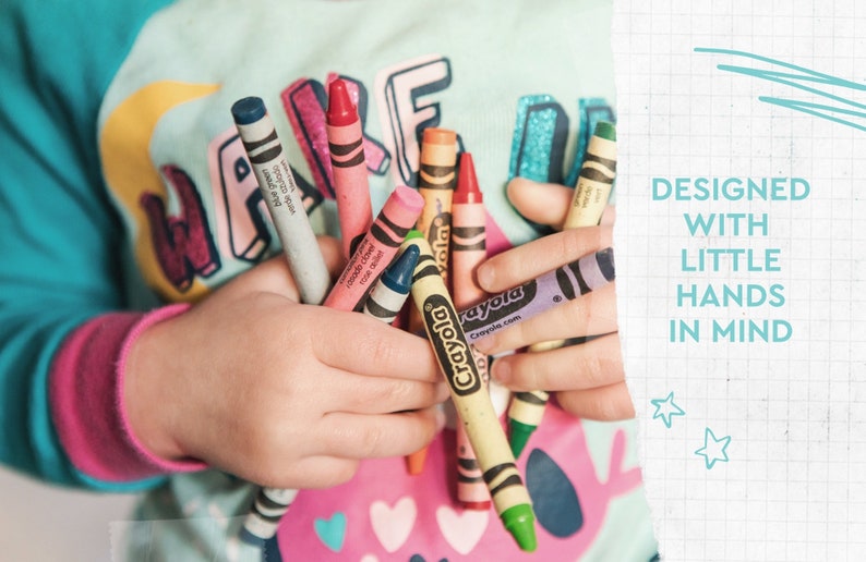 May include: A child's hands holding a collection of Crayola crayons in various colors, including blue, pink, and yellow. The image includes the text "DESIGNED WITH LITTLE HANDS IN MIND".
