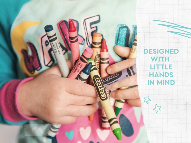 May include: A child's hands hold a collection of Crayola crayons in various colors, including blue, pink, and yellow. The image includes the text "DESIGNED WITH LITTLE HANDS IN MIND."