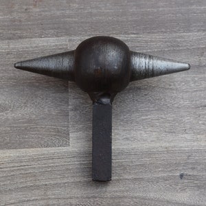 Könnte beinhalten: Ein schwarzer Metallhammer mit einem runden Kopf und zwei spitzen Enden. Der Hammer hat einen langen, rechteckigen Stiel.