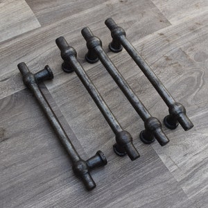 Op de afbeelding: Vijf zwarte metalen ladegrepen met afgeronde uiteinden. De grepen zijn in een rij gerangschikt, met de langste greep bovenaan en de kortste greep onderaan.