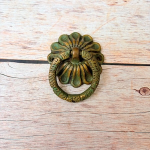 Puede incluir: Una taza de cerámica blanca con un asa negra y el texto "But First, Coffee" en negro, con una fuente de estilo manuscrito. La taza está sobre una superficie blanca.